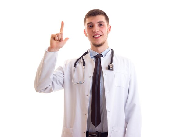 Giovane uomo sorridente con capelli castani in cravatta blu e abito medico bianco con stetoscopio