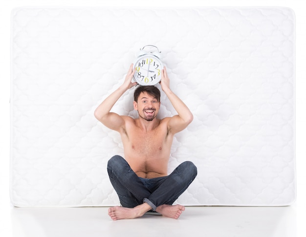 Young smiling man with a white mattress.