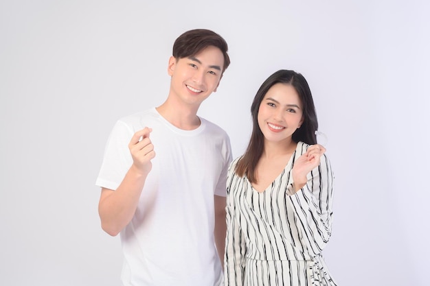 Young smiling man and woman holding invisalign braces over white background