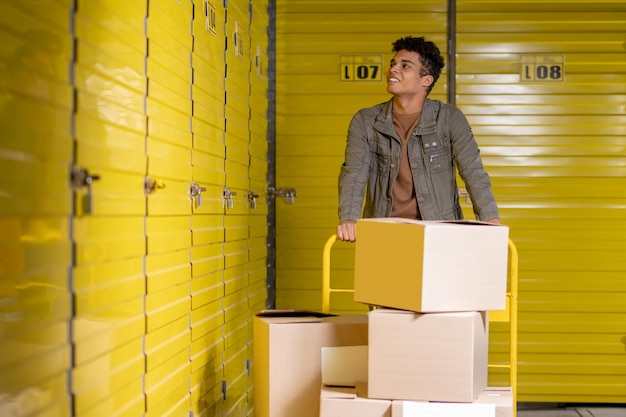 Photo young smiling man working in a warehouse and distributing boxes