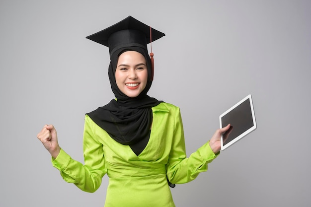 Giovane donna musulmana sorridente con l'hijab che indossa il cappello di laurea per l'istruzione e l'università conceptx9