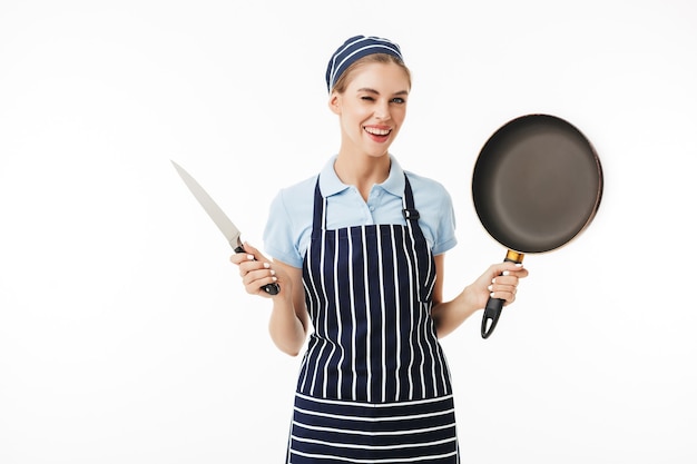 Young smiling woman cook in striped apron and cap happily winking while 