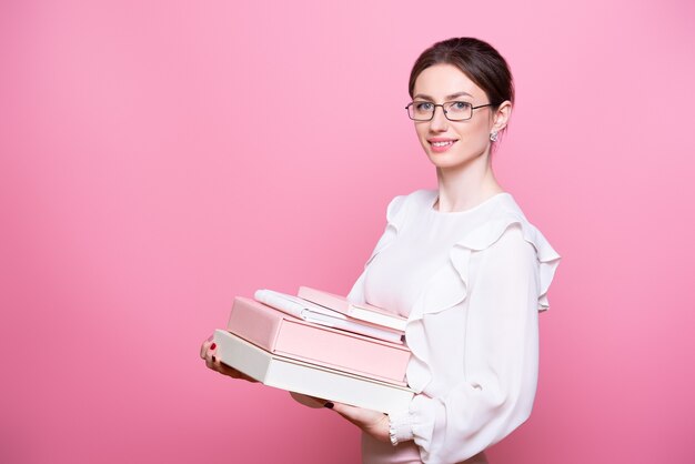 Young smiling woman in glasses holds folders.