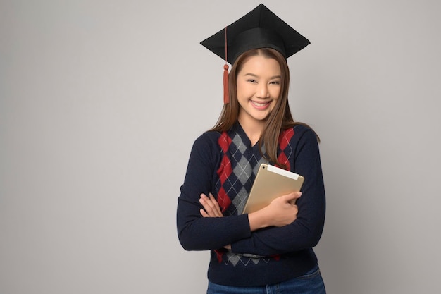 Young smiling woman holding graduation hat education and\
university conceptx9