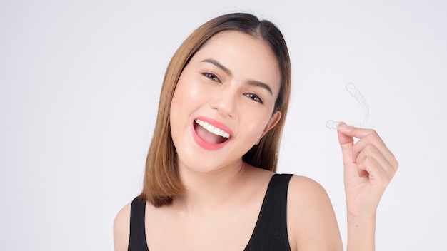 스튜디오, 치과 의료 및 교정 개념에서 invisalign 교정기를 들고 웃는 젊은 여성