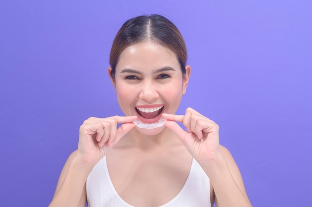 스튜디오, 치과 의료 및 교정 개념에서 invisalign 교정기를 들고 웃는 젊은 여성