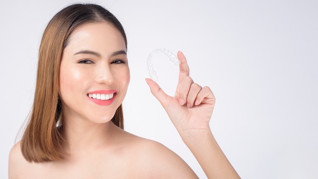 스튜디오, 치과 의료 및 교정 개념에서 invisalign 교정기를 들고 웃는 젊은 여성