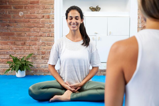 Young smiling woman meditating in a yoga class smile to life
