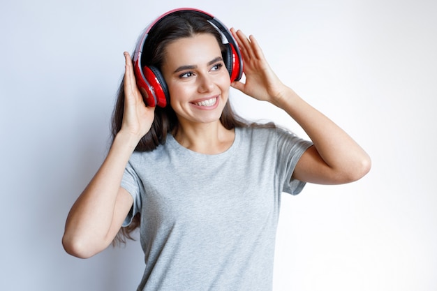 Young smiling woman in modern headphones listening music White background