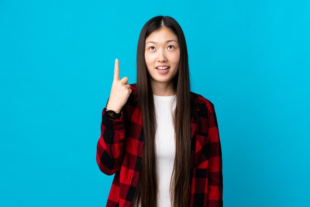 Young smiling woman pointing up