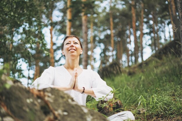 Photo young smiling woman practice yoga outdoors in forest new normal social distance physical and