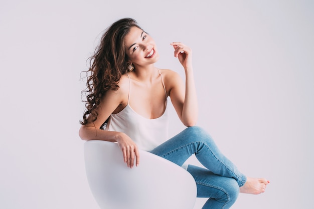 Young smiling woman sitting on modern chair.