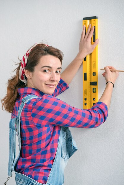 Young smiling woman using spirit level