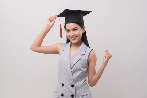 Giovane donna sorridente che indossa il cappello di laurea per l'istruzione e l'università conceptx9