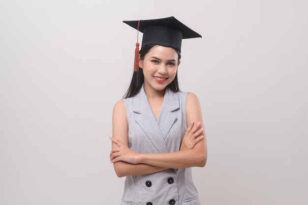 Giovane donna sorridente che indossa l'educazione e l'università del cappello di laurea