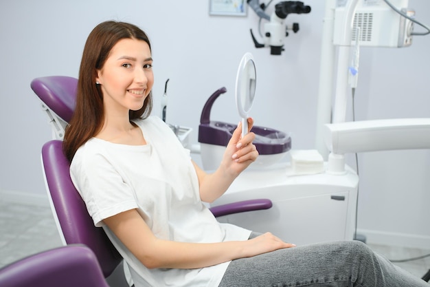 歯科検査を持つ美しい歯を持つ若い笑顔の女性
