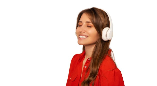 Young smiling woman with eyes closed enjoys music while wearing headphones