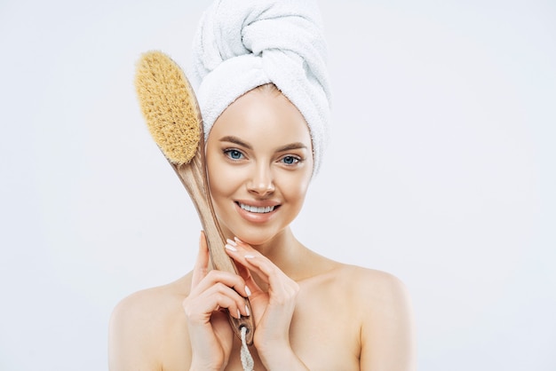 Young smiling woman with natural makeup gentle smile healthy skin holds bath brush