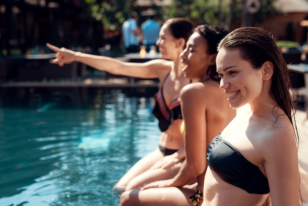 Young Smiling Women Sitting at Poolside