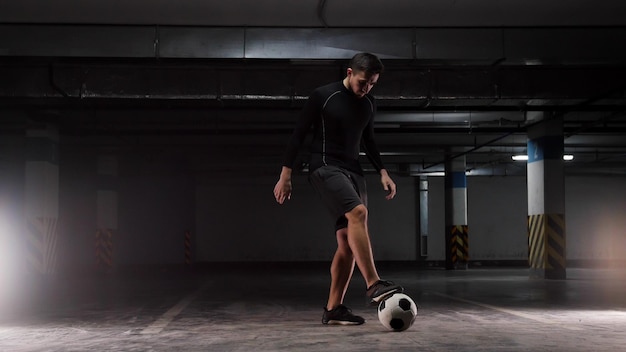 A young soccer man training the basic tricks with the ball