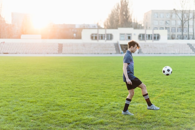 Young soccer player juggling ball