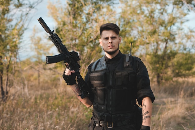 Young soldier in black uniform with an assault rifle