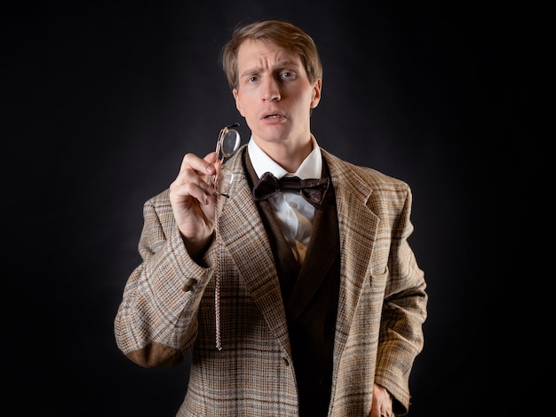 A young, solid man in the image of a Victorian scientist, a university teacher or a natural scientist. Vintage retro suit, young attractive man in a vest and bow tie