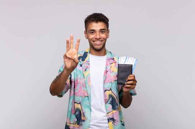 Young south american man smiling and looking friendly, showing number three or third with hand forward, counting down