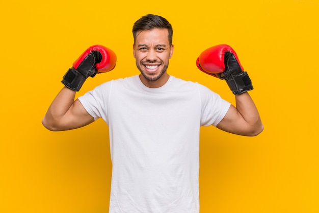 Young south asian boxer man wearing red gloves.