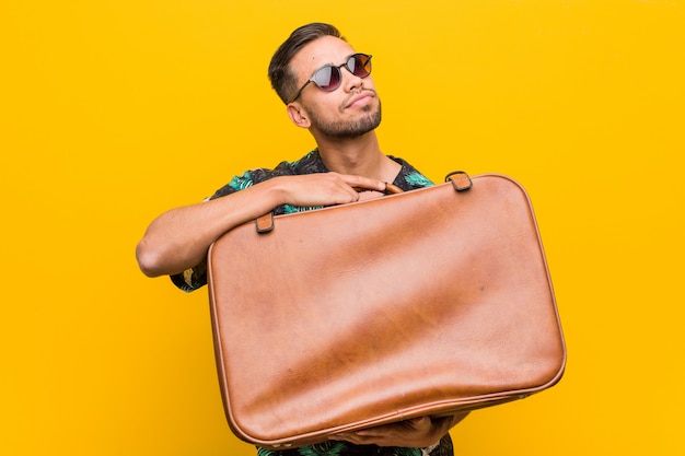 Young south-asian man holding a leather case