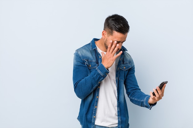 Young south-asian man holding a phone