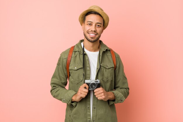 Photo young south-asian man holding a retro camera