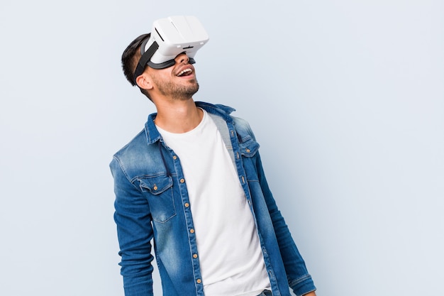 Young south asian man playing with virtual reality glasses