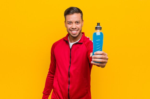 Young south-asian sport man holding an energy drink