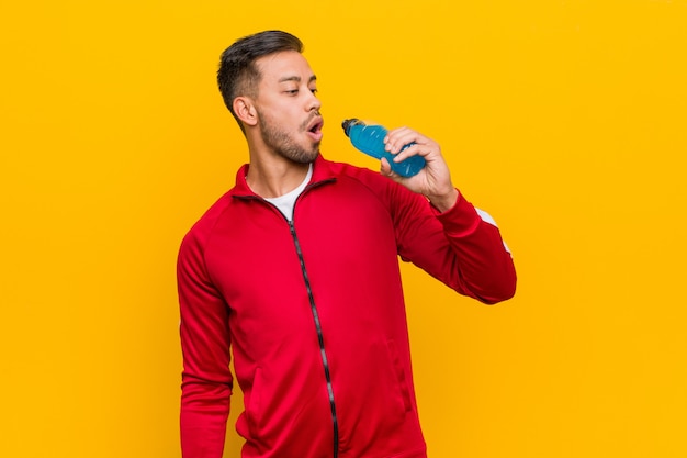 Young south-asian sport man holding an energy drink.