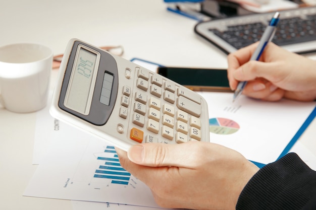 A young specialist works with financial documents at a computer