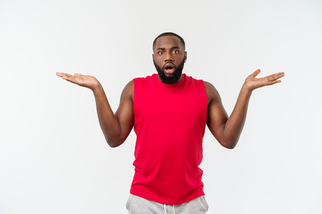 Young sport african american man extending hands to the side for inviting to come.