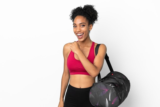 Young sport african american woman with sport bag isolated on blue background celebrating a victory