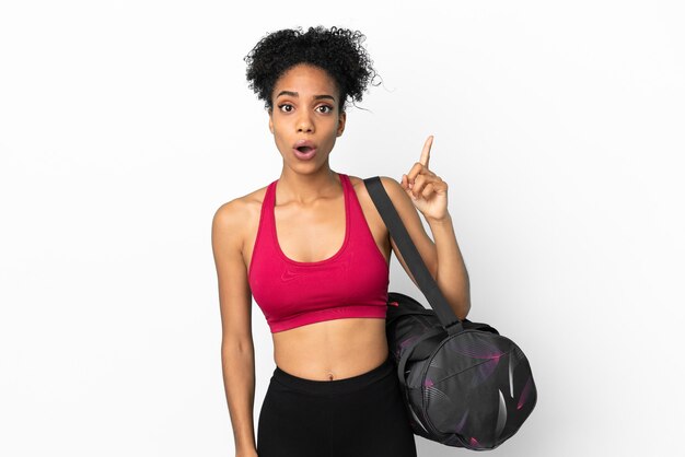 Young sport african american woman with sport bag isolated on blue background intending to realizes the solution while lifting a finger up