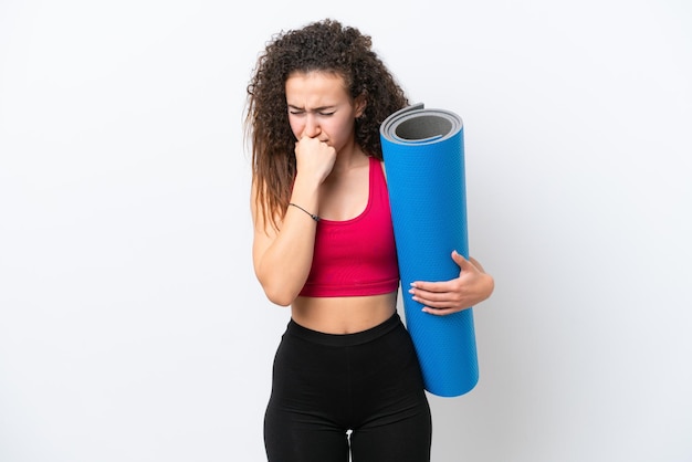Young sport Arab woman going to yoga classes while holding a mat isolated on white background having doubts