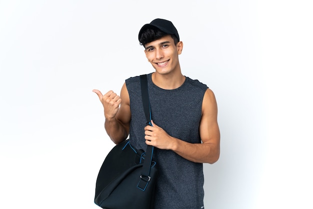 Young sport Argentinian man with sport pointing to the side to present a product