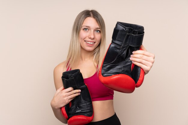 Donna bionda giovane sportivo con guantoni da boxe