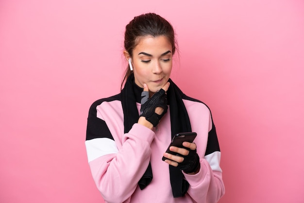 Young sport Brazilian woman isolated on pink background thinking and sending a message