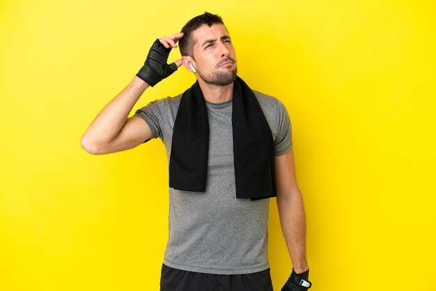 Young sport caucasian man isolated on yellow background having doubts and with confuse face expression