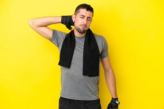 Young sport caucasian man isolated on yellow background with neckache