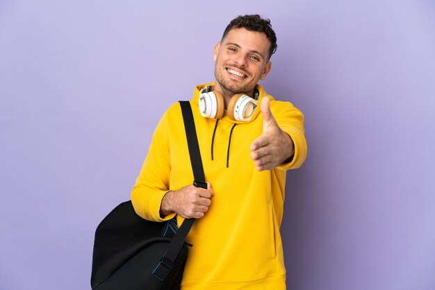 Young sport caucasian man with bag isolated