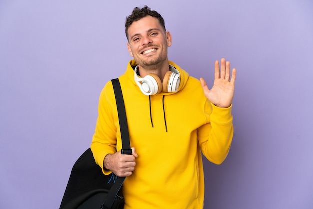 Young sport caucasian man with bag isolated