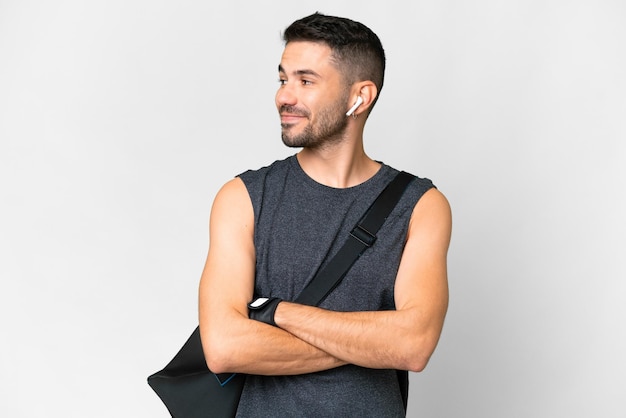 Young sport caucasian man with sport bag over over isolated white background happy and smiling