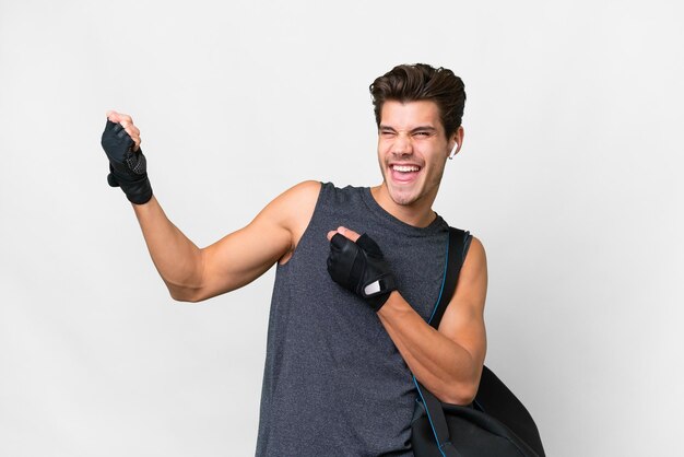 Young sport caucasian man with sport bag over isolated white background making guitar gesture