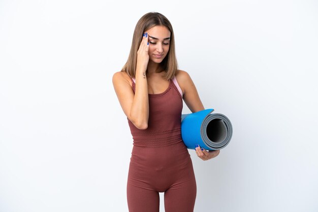 young sport caucasian woman going to yoga classes isolated on white background with headache
